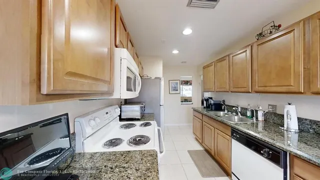 a kitchen with stainless steel appliances granite countertop a sink stove and cabinets