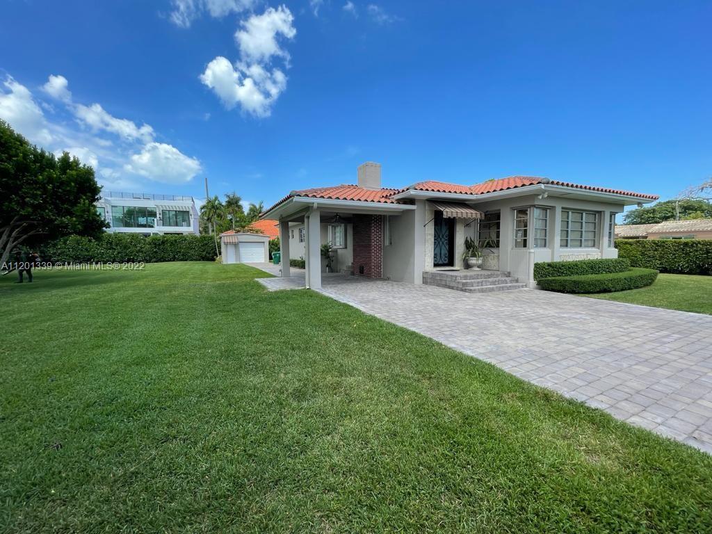 a front view of a house with a garden and yard