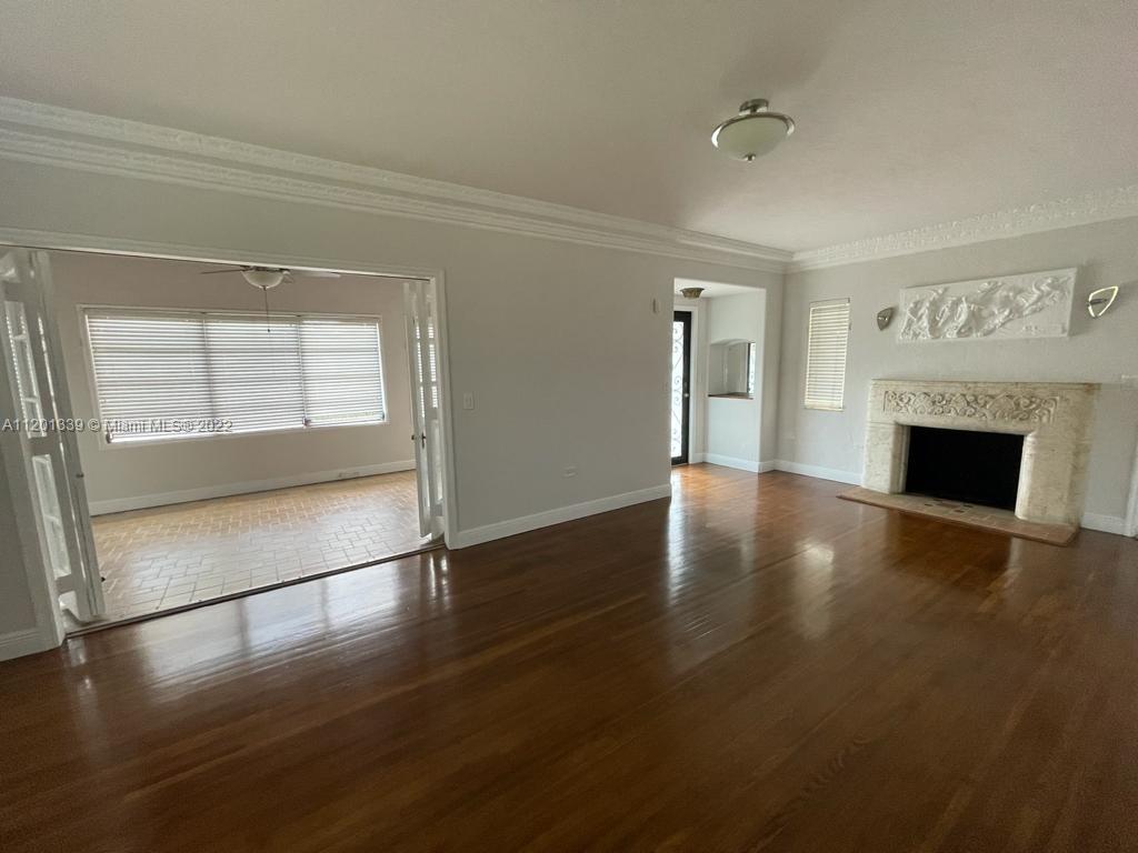 501 Southwest 24th Road Miami, FL 33129 - Photo 6 of 25 an empty room with wooden floor fireplace and windows