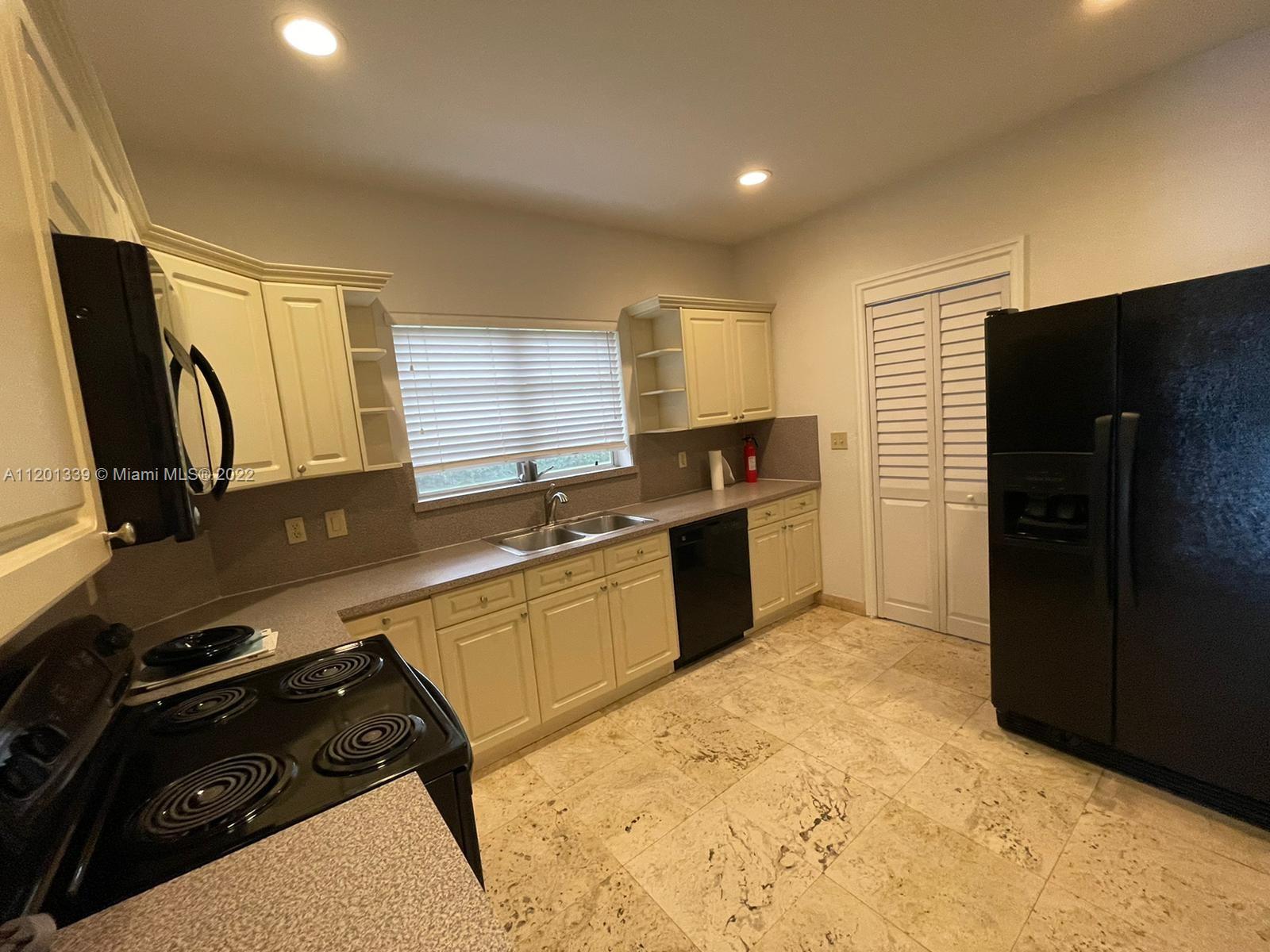 501 Southwest 24th Road Miami, FL 33129 - Photo 9 of 25 a kitchen with a stove a refrigerator and a sink