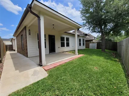 a view of a house with a yard and large tree