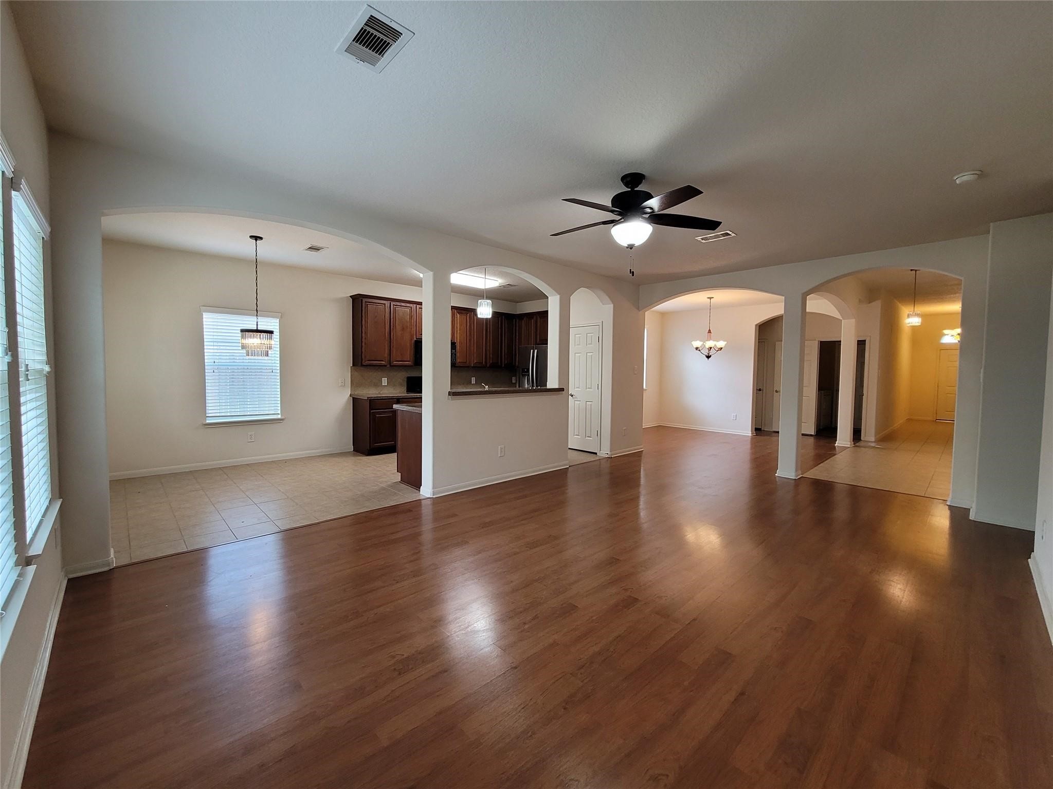 438 Oak Gate Drive Conroe, TX 77304 - Photo 6 of 18 an empty room with wooden floor and a chandelier