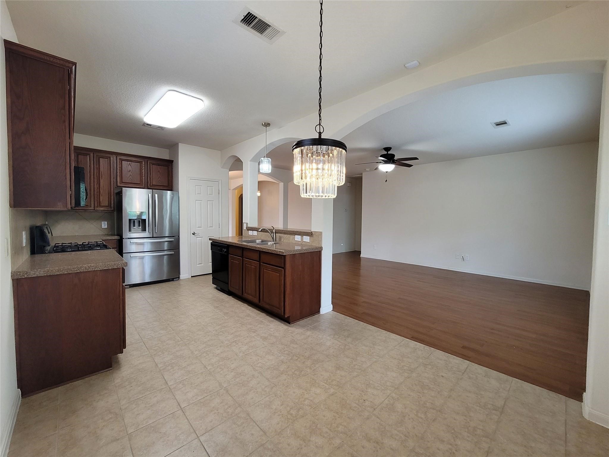 438 Oak Gate Drive Conroe, TX 77304 - Photo 7 of 18 a large kitchen with a stove a refrigerator and a wooden cabinets