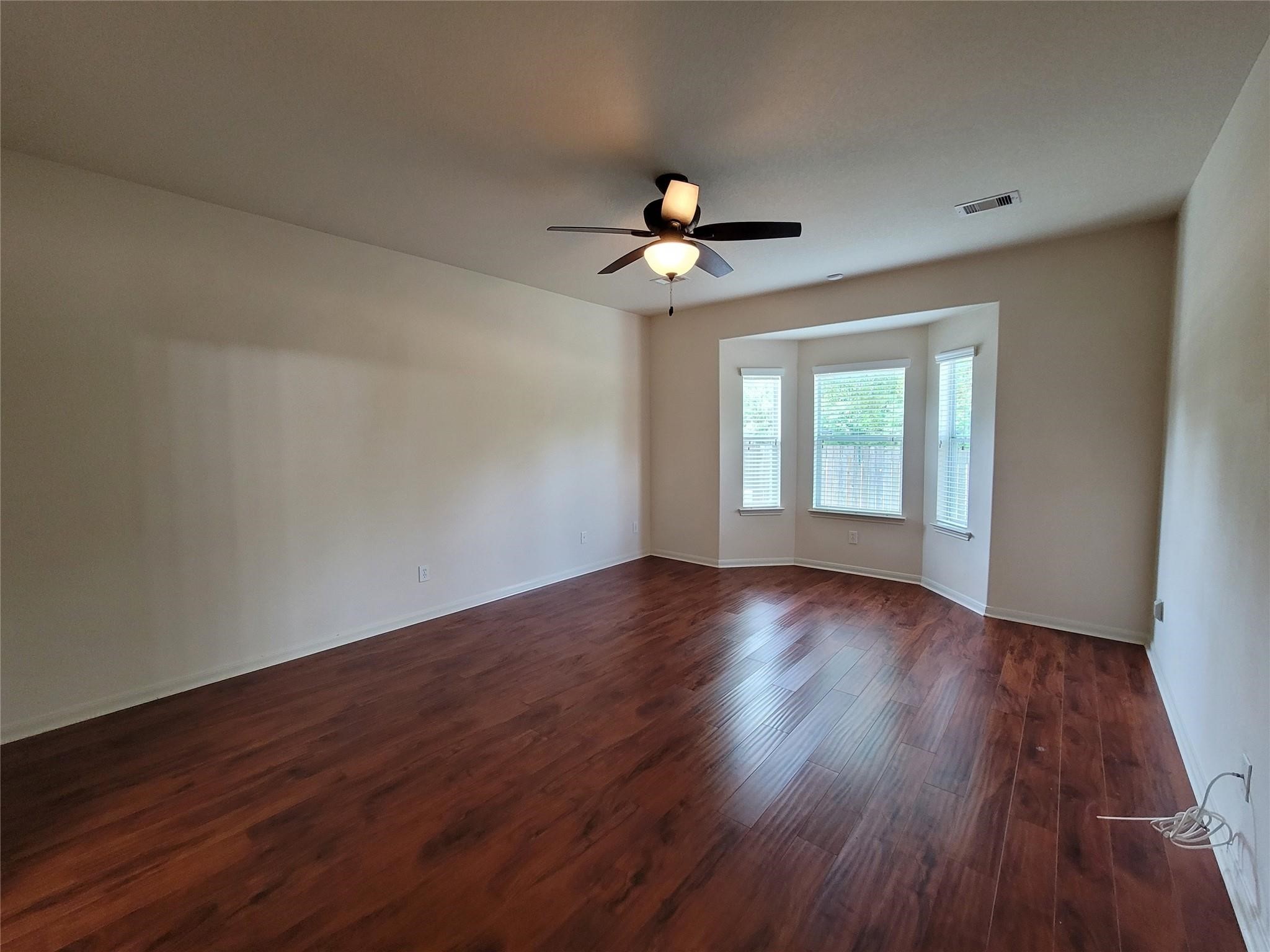 438 Oak Gate Drive Conroe, TX 77304 - Photo 9 of 18 a view of an empty room with wooden floor and a window