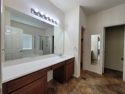 a spacious bathroom with a sink a large mirror and a shower