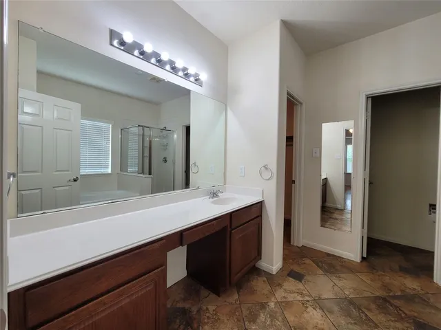 a spacious bathroom with a sink a large mirror and a shower