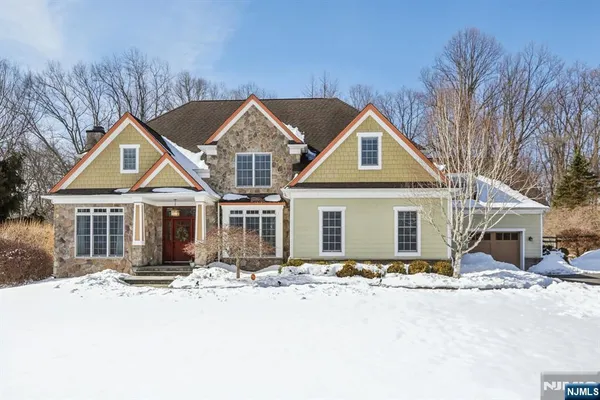 a front view of a house with yard and covered with snow