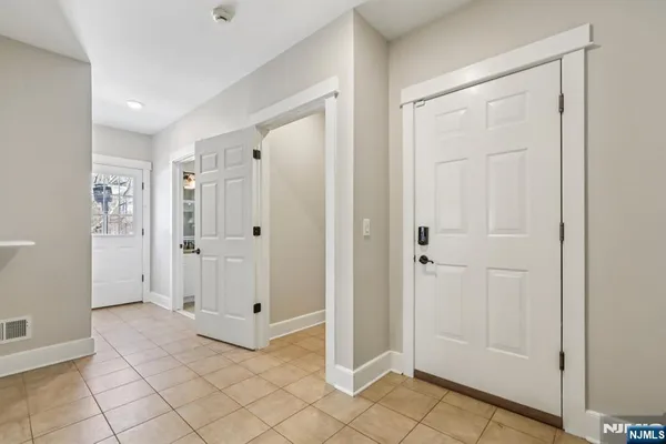 a large white kitchen with a stove a sink dishwasher and cabinets with wooden floor