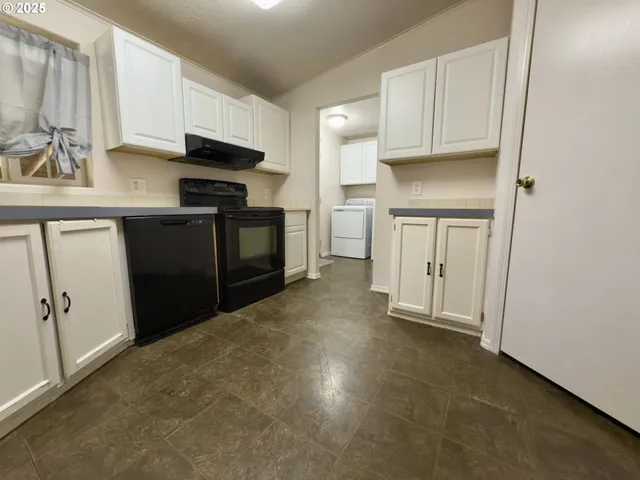 a kitchen with cabinets and a stove top oven