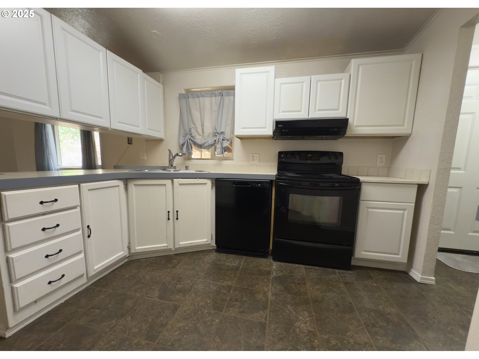 98041 Hallway Road, Unit 26 Brookings, OR 97415 - Photo 15 of 46 a kitchen with granite countertop white cabinets and stainless steel appliances
