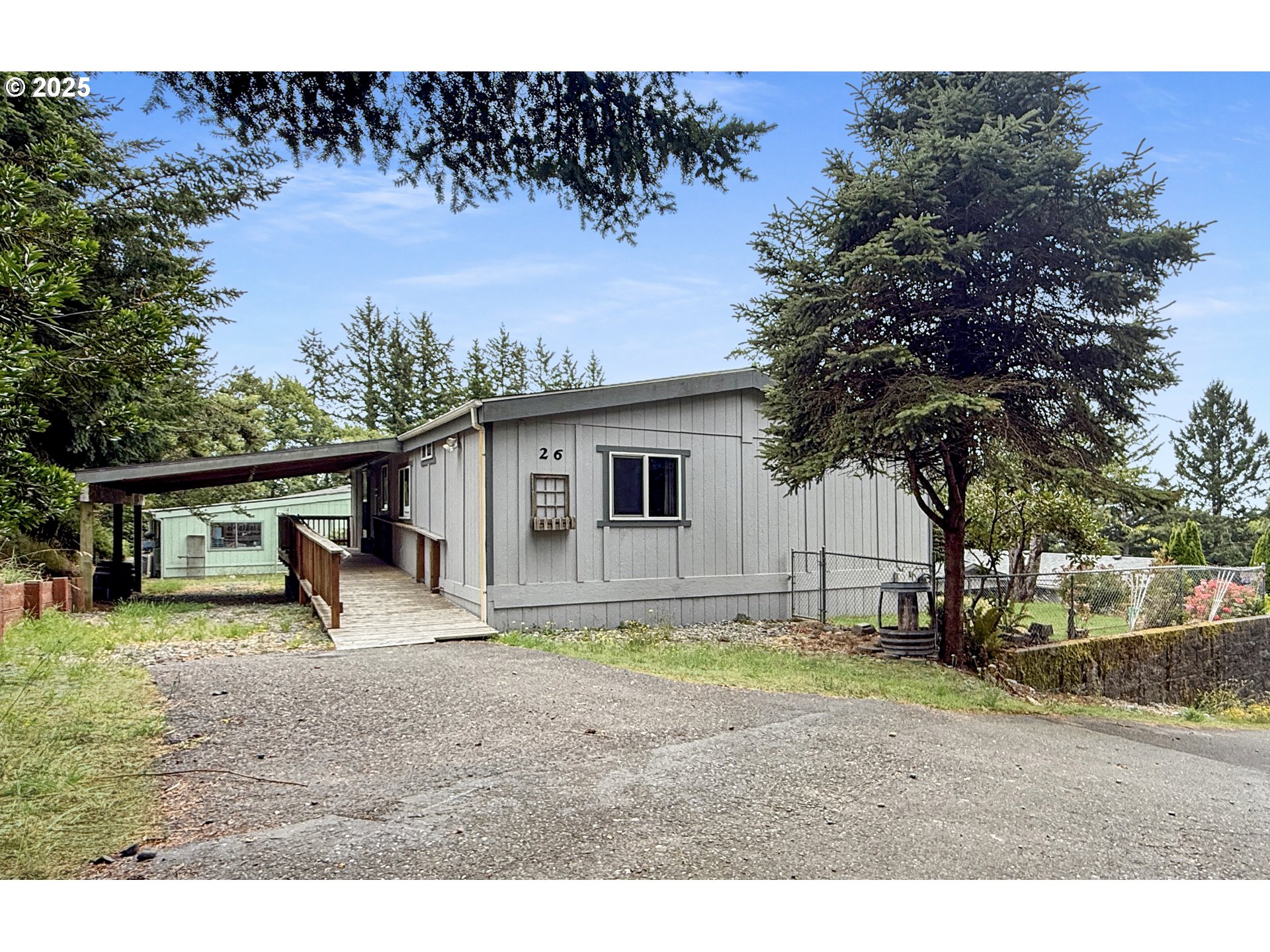 98041 Hallway Road, Unit 26 Brookings, OR 97415 - Photo 2 of 46 a backyard of a house with barbeque oven table and chairs