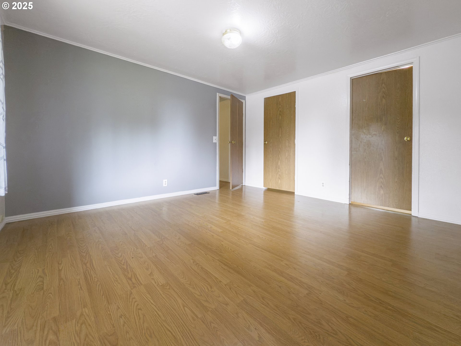 98041 Hallway Road, Unit 26 Brookings, OR 97415 - Photo 22 of 46 a view of an empty room with wooden floor and a window