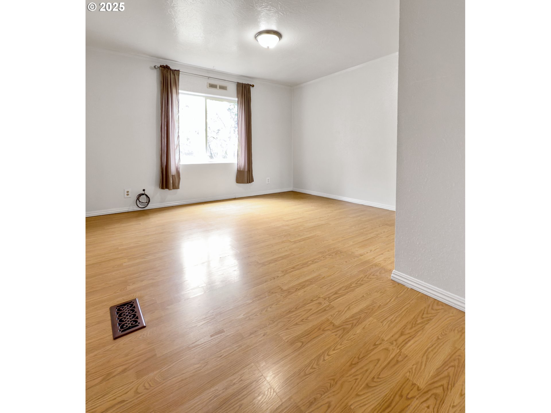 98041 Hallway Road, Unit 26 Brookings, OR 97415 - Photo 27 of 46 a view of an empty room with wooden floor and a window