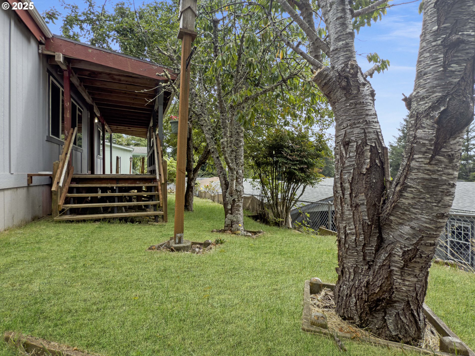 98041 Hallway Road, Unit 26 Brookings, OR 97415 - Photo 43 of 46 a view of a backyard with wooden fence and a large tree