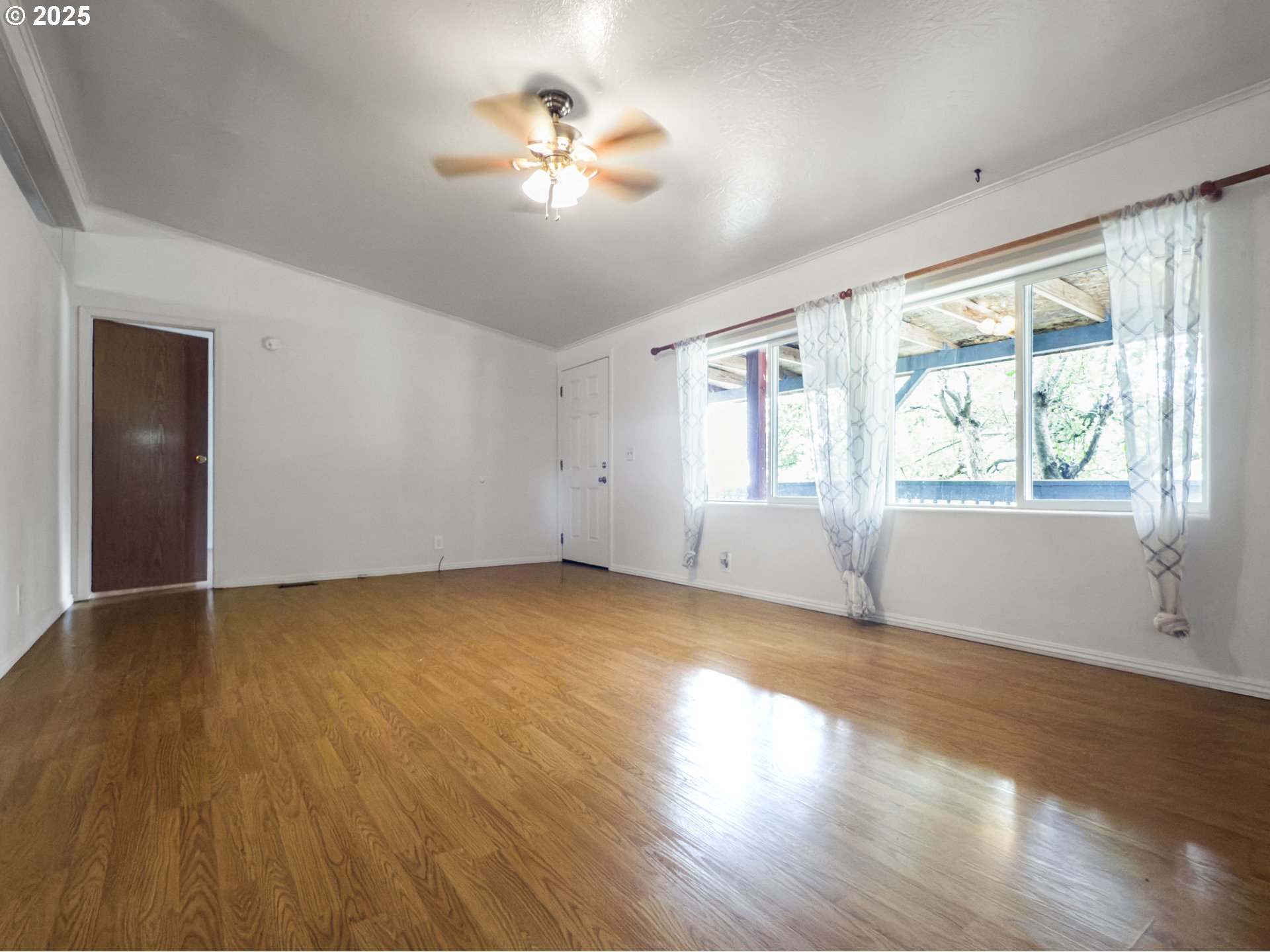 98041 Hallway Road, Unit 26 Brookings, OR 97415 - Photo 9 of 46 an empty room with wooden floor and windows