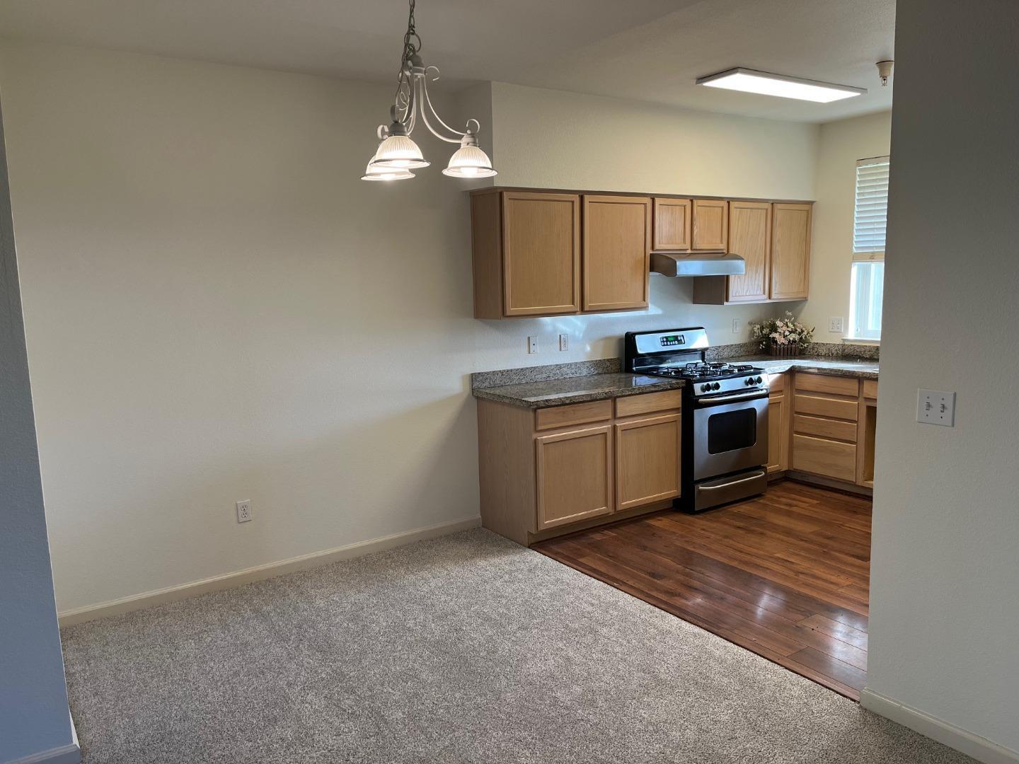 213 Pacifica Boulevard, Unit 202 Watsonville, CA 95076 - Photo 10 of 19 a kitchen with stainless steel appliances granite countertop a sink a stove top oven a chimney and a refrigerator