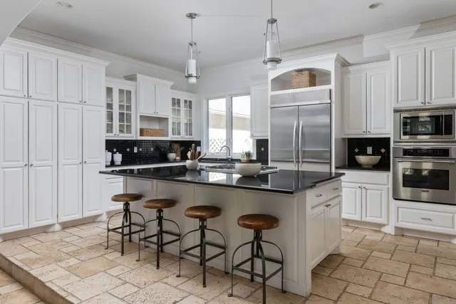 a kitchen with stainless steel appliances granite countertop a stove a sink and a refrigerator