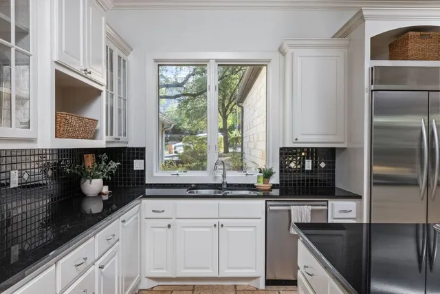 a kitchen with granite countertop a sink stainless steel appliances and cabinets