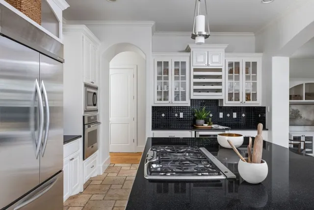 a kitchen with stainless steel appliances granite countertop a stove a refrigerator and a counter top space