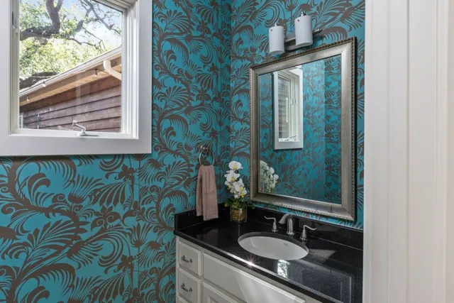 a bathroom with a granite countertop sink and a mirror