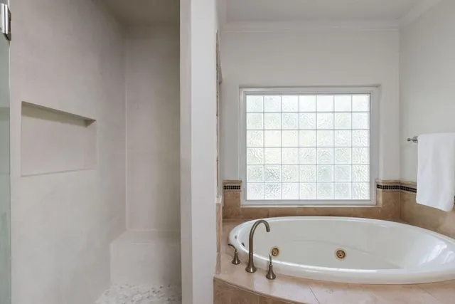a white bath tub sitting in a bathroom next to a window