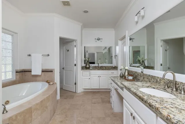 a bathroom with a granite countertop tub sink and mirror
