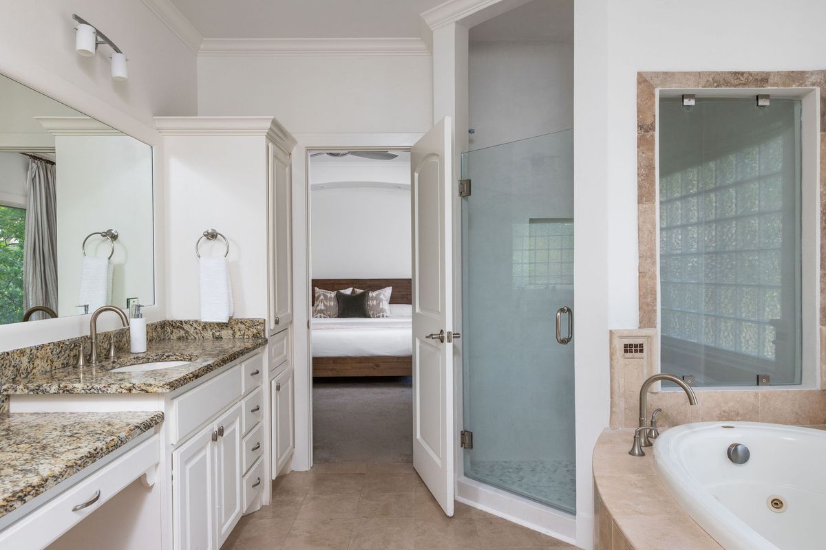 2308 West 9th Street, Unit B Austin, TX 78703 - Photo 30 of 40 a bathroom with a granite countertop tub sink and mirror