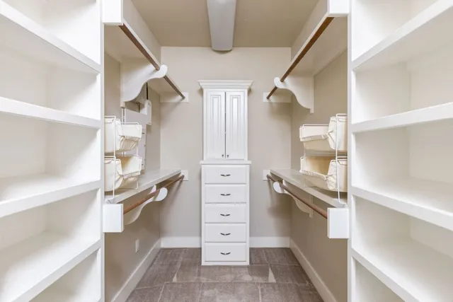 a view of walk in closet with clothes and shoes