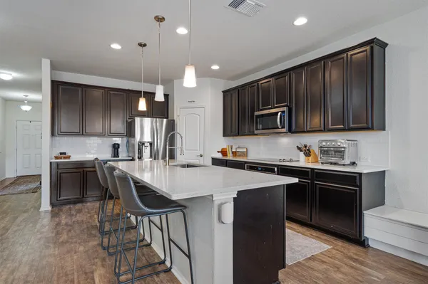 a kitchen with stainless steel appliances a stove sink microwave and cabinets