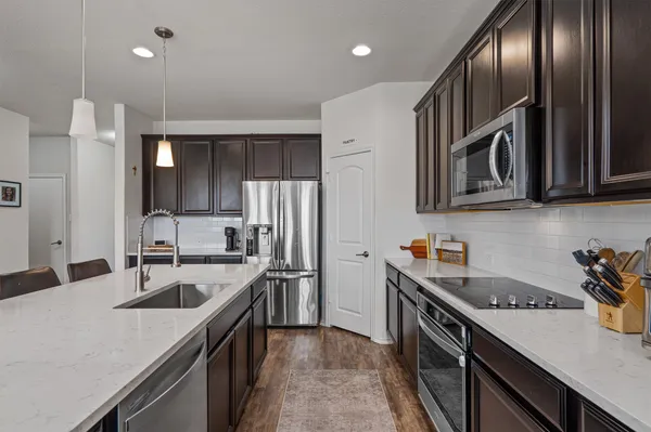 a kitchen with stainless steel appliances granite countertop a sink stove and refrigerator