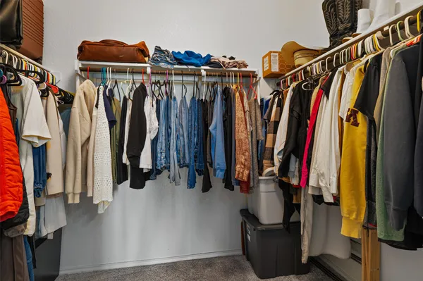 a view of walk in closet with clothes and shoes