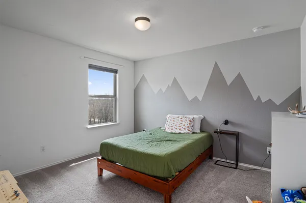 a bedroom with a bed and windows