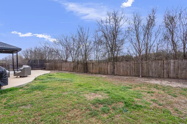 a view of a backyard with a garden and tree