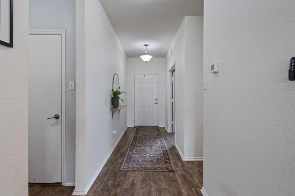 a view of a hallway with wooden floor and closet