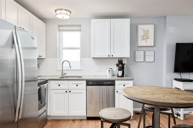 a kitchen with stainless steel appliances granite countertop a sink refrigerator and cabinets