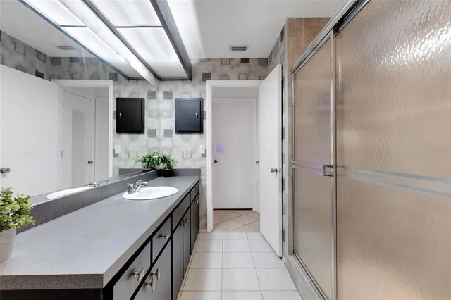 a spacious bathroom with a sink a large mirror and a shower