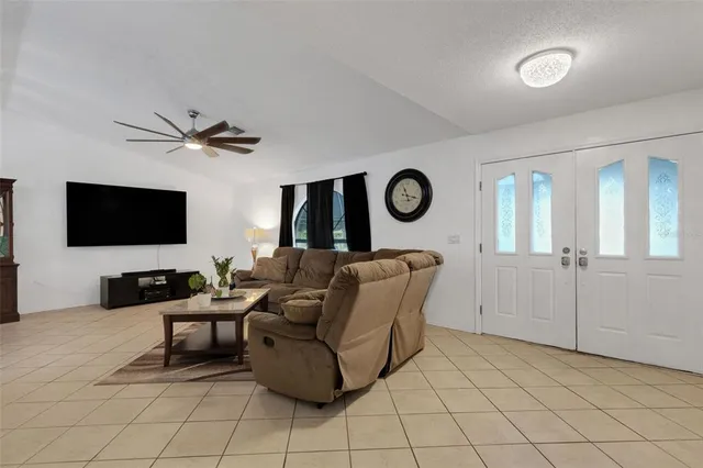 a living room with furniture a flat screen tv and a wall painting