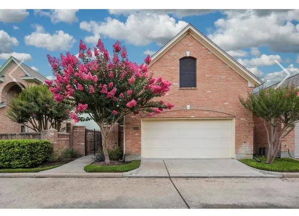 a front view of a house with a yard and potted plants
