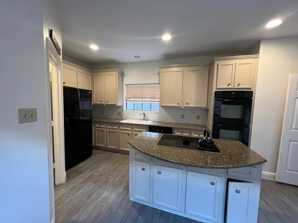 a kitchen with granite countertop a refrigerator stove top oven and sink