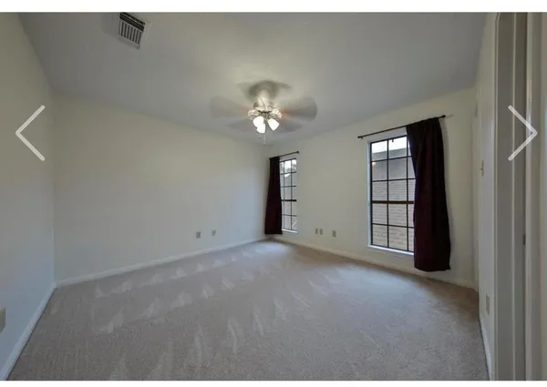 a view of an empty room with a ceiling fan