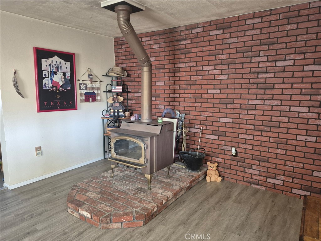 63737 Gibson Road Joshua Tree, CA 92252 - Photo 12 of 25 a room with a wooden floor and a fireplace