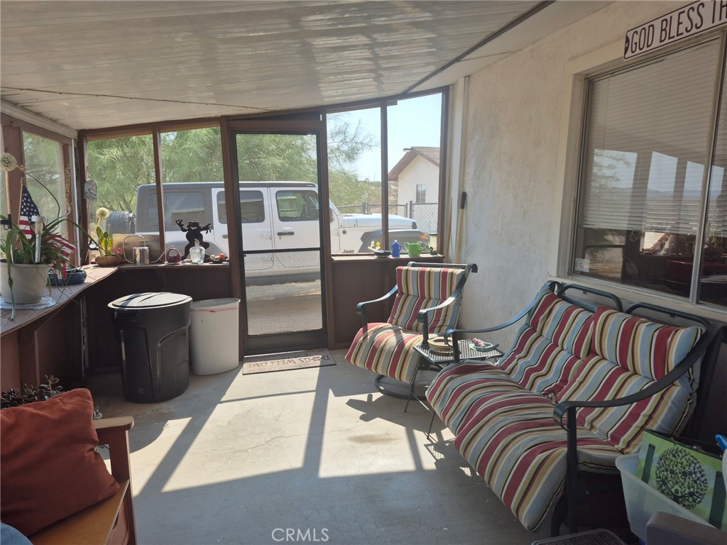 63737 Gibson Road Joshua Tree, CA 92252 - Photo 6 of 25 a view of a dining room with furniture large windows and wooden floor