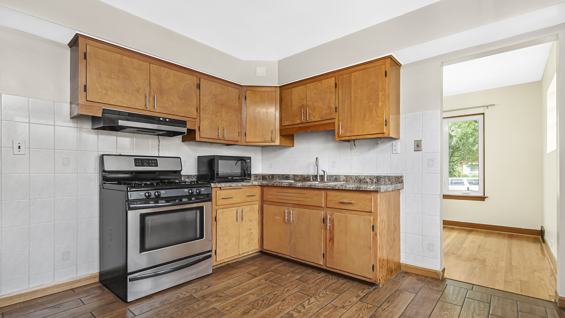 2322 South 7th Avenue North Riverside, IL 60546 - Photo 9 of 21 a kitchen with stainless steel appliances granite countertop a stove a sink and a microwave