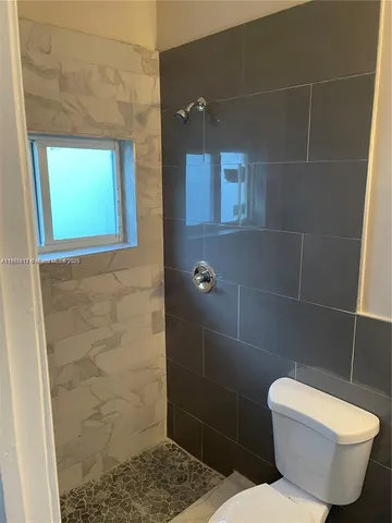 a bathroom with a toilet and a shower