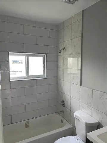 a bathroom with a toilet and bathtub
