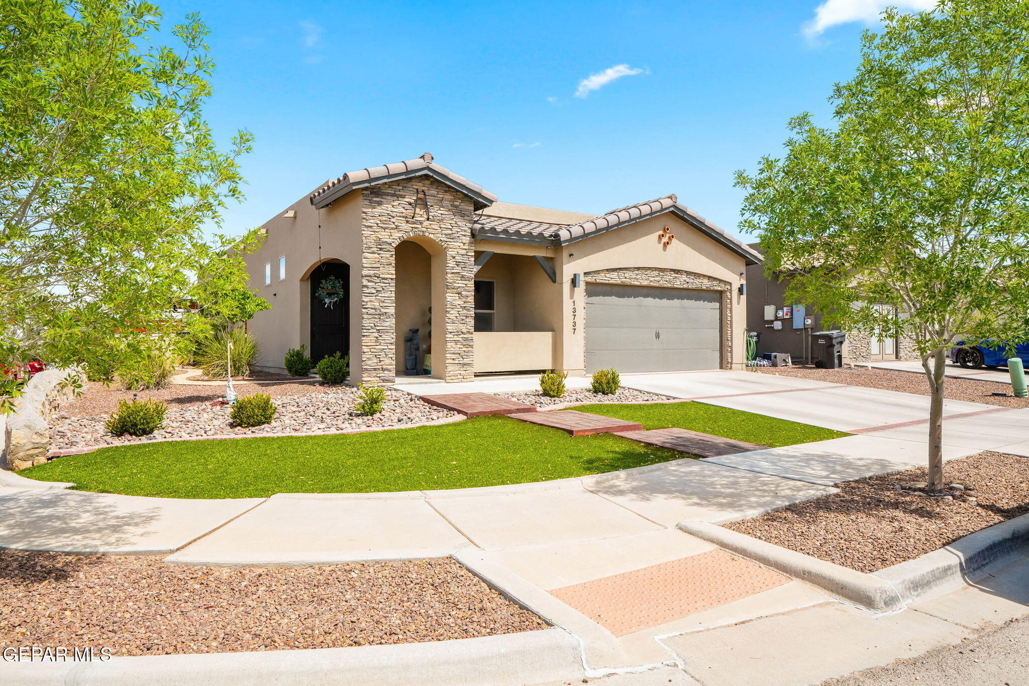 13737 Garforth Avenue El Paso, TX 79928 - Photo 3 of 34 a front view of a house with a yard and garage