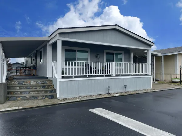 a white house with a large window and wooden fence