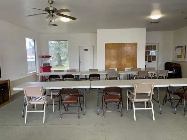 a open dining room with stainless steel appliances kitchen island granite countertop furniture and a large window