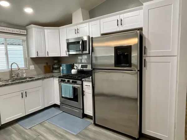 a kitchen with stainless steel appliances granite countertop a refrigerator and a stove