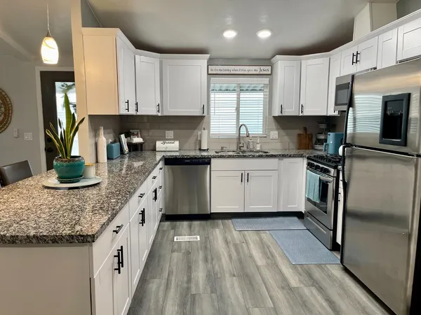 a kitchen with stainless steel appliances granite countertop a sink stove and refrigerator